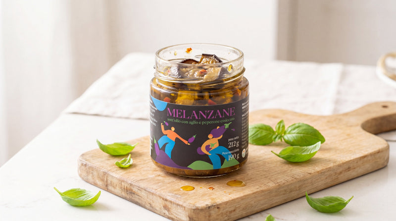 Vasetto aperto di melanzane sott'olio su tagliere di legno chiaro con foglie di basilico