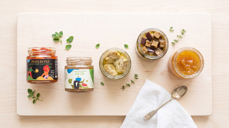 Dispensa con vari sottoli e confetture vegane: peperoni, melanzane, carciofini, confetture di frutta