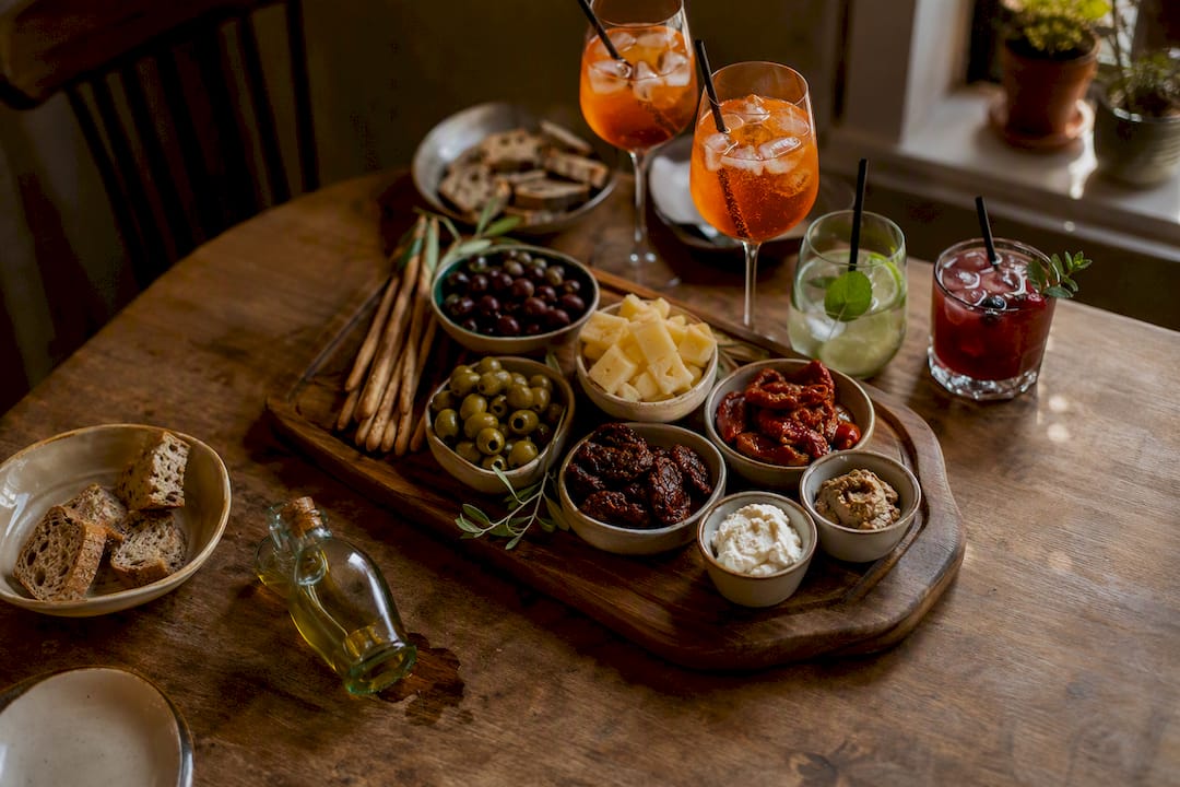 Rustikaler Tisch mit mediterranen Aperitivo-Snacks und Getränken