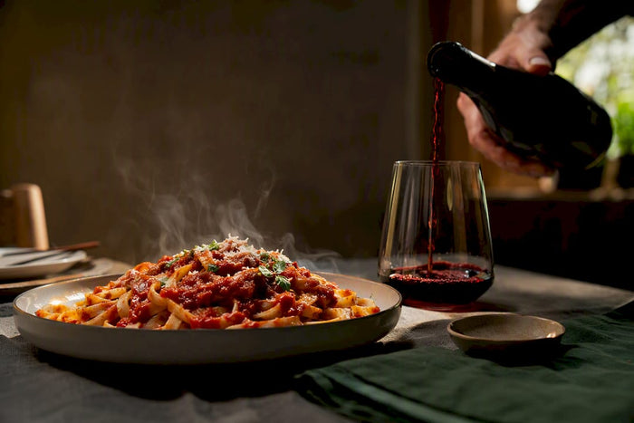 Pasta mit Tomatensauce und einem Glas Rotwein