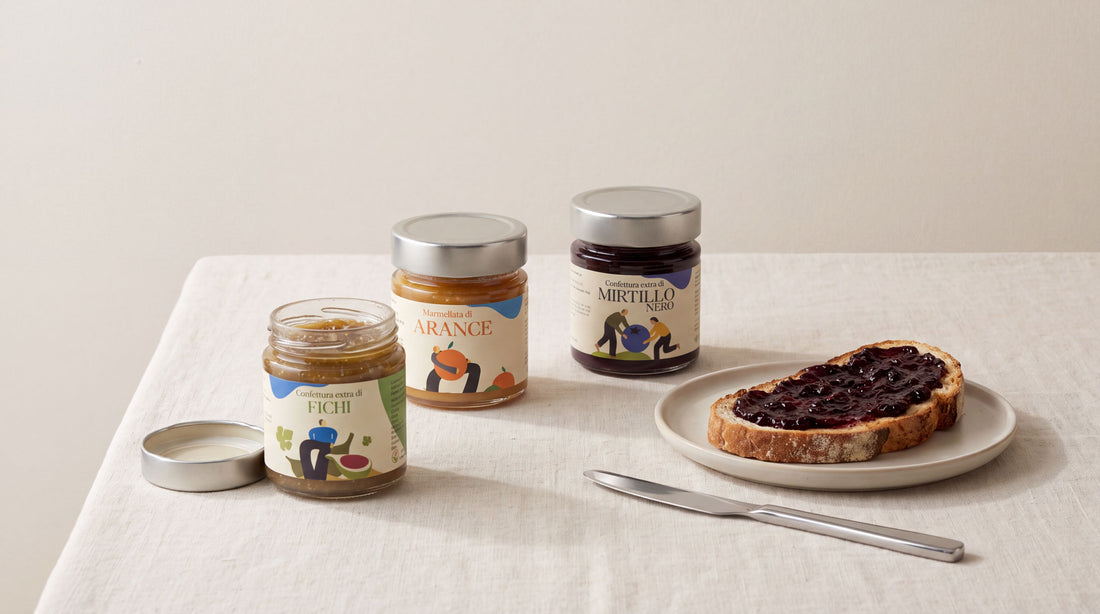 Trois pots de confiture artisanale italienne et une tartine sur nappe en lin creme