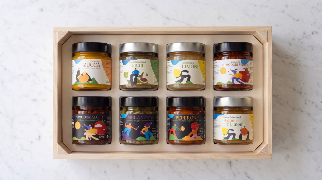 Huit bocaux de conserves artisanales italiennes dans une caisse en bois clair, coffret cadeau d'entreprise