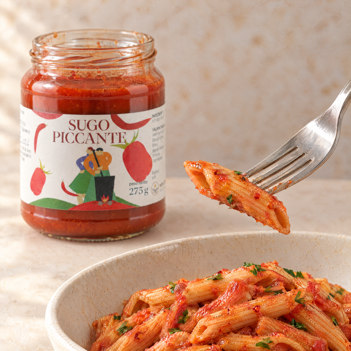 Dettaglio di una penna all’arrabbiata sulla forchetta con Sugo Piccante Minnelea.