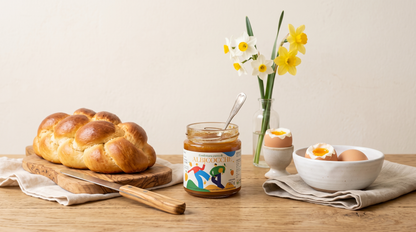 Tavola del brunch con confettura extra di albicocche Minnelea, treccia dolce e uova