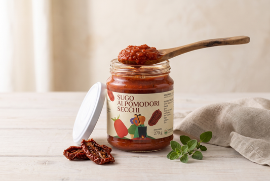 Sugo ai pomodori secchi Minnelea nel vasetto aperto con cucchiaio di legno e pomodori secchi